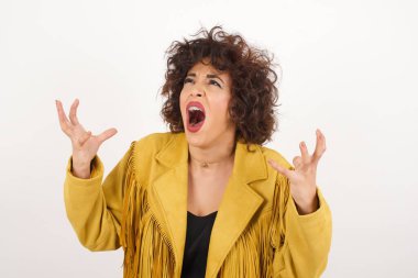 Çığlık, nefret, öfke. Mavi stüdyo arka planında ağlayan duygusal sinirli kadın. Duygusal, genç yüz. Yarım boy kadın portresi. İnsani duygular, yüz ifadesi kavramı. Moda renkleri