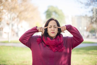 Parktaki tapınaklarda elleri olan orta yaşlı güzel bir Arap kadın.  