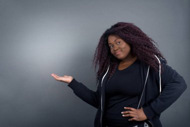 Afro-mutlu Afro-Amerikan kadın gündelik giysiler içinde diyor ki: Vay be, ne kadar heyecan verici, hayret verici bir ifade, boş alanda boş bir alanda kapalı bir arkaplan üzerinde bir şeyler gösteriyor. Reklam kavramı.