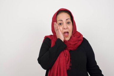 Şaşırdım. Kadın yüz yüze bakarken heyecanlanıyor. Heyecandan yana bakan mutlu Müslüman kadın şaşırdı. Gri arka planda kadın model. Stüdyoda poz veren başörtüsü takan orta yaşlı bir Arap kadın.