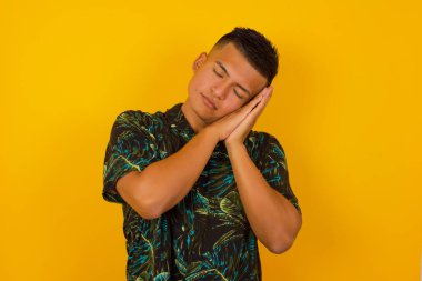 Rahatla ve uyu. Yorgun, yakışıklı, gözleri kapalı, yastık gibi avuçlarına yaslanmış, yorgun düşmüş gibi yapan, arka planda duran rüyalar gören İspanyol bir adam. Uyuma hareketi.