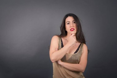 Gri arka planda poz veren güzel kadın. 