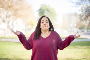 Güzel orta yaşlı bir Arap kadının parkta kafası karışıyor.  