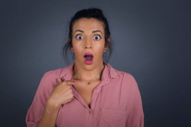 Şaşırmış güzel bir kadın sersemlemiş durumda, şaşkın bir şekilde kendini işaret ederek 