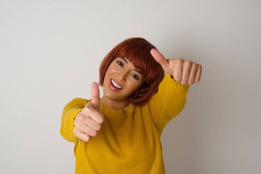  Aşırı izole edilmiş arka planda yaşayan bir kadın elleriyle olumlu bir jest yapmayı onaylıyor, gülümseyerek ve başarı için mutlu. Kameraya bak, kazanan jest..