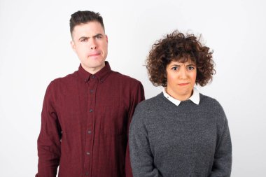 Düşüncelere dalan, kaşlarını kaldıran, dudaklarını kıvıran, şık kıyafetler giyen, metin için duvarda duran düşünceli çekici çift..