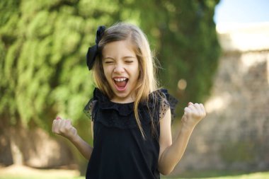 Güzel esmer kızın portresi kameraya heyecanla bakıyor, ellerini başının üstüne kaldırıyor, beklenmedik bir şey fark ediyor.