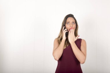 Stüdyoda telefonu olan genç ve güzel bir kadın.