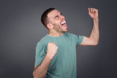 Çekici, beyaz bir adam zaferi kutluyor yumruklarıyla havaya yumruk atıyor ve mavi bir stüdyonun arka planında sahte uzay ile ışıl ışıl gülümsüyor..