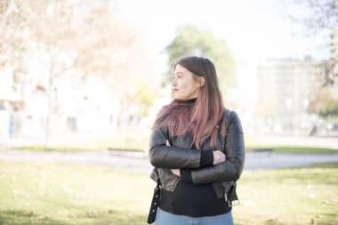 Genç ve güzel bir kadın parka bakıyor. 