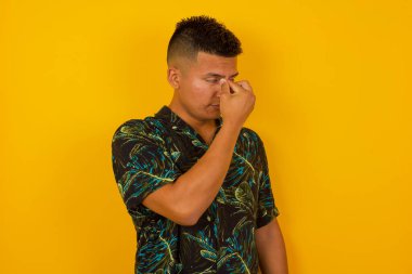 Çok üzgün, çekici, İspanyol bir adam açık havada dururken burnuna dokunuyor, ağlamak istiyor, stresli bir ilişkisi var, sevgilisiyle anlaşmazlık yaşıyor ya da işiyle ilgili sorunları var.