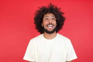 Kızıl duvara bakan afro saçlı genç adam.   