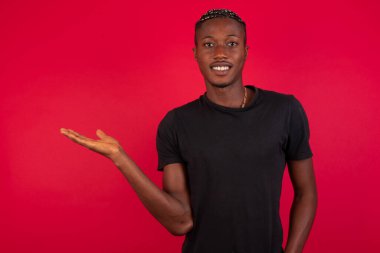 Kırmızı arka planda siyah tişört giyen Afro-Amerikan bir adam, 