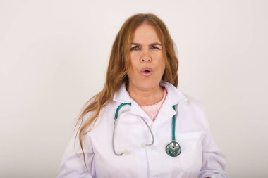 Esmer doktor kadın tiksindiğini, isteksiz olduğunu, hoşlanmadığını, gergin suratını görmezden geldiğini ifade ediyor. Cauasian bir kadın, hoş görünümlü. Sinir bozucu görünüyor.