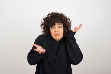 Güzel bir kadın ifadeden şüphe eder, şaşırır ve şaşırır, belirsiz bir gelecek omuzlarını silker, gri duvara karşı durur..