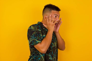 Şok olmuş yüz ifadesi olan genç bir İspanyol 'un portresi. Yüzünün yanında el ele tutuşuyor, çığlık atıyor ve şaşırtıcı bir şeye yan gözle bakıyor. Gri stüdyo duvarına karşı duruyor..