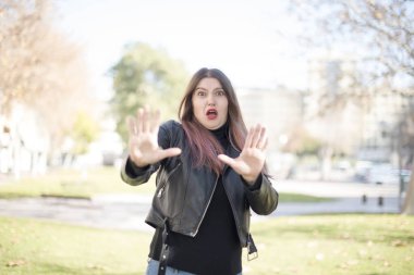 Genç ve güzel bir kadın parkta duruyor.