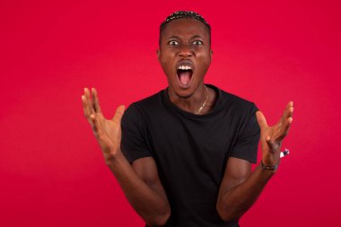 Çığlık, nefret, öfke. Ağlayan kızgın Afrikalı Amerikalı adam mavi stüdyo arka planında çığlık atıyor. Duygusal, genç yüz. Yarım boy portre. İnsani duygular, yüz ifadesi kavramı. Moda renkleri