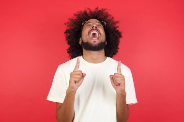 Kızıl duvara dayanmış afro saçlı genç adam.   