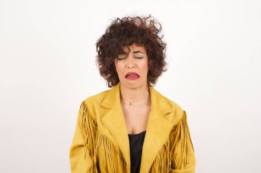 Süet ceketli, ağlayan stüdyo fotoğrafı olan güzel bir kadın.
