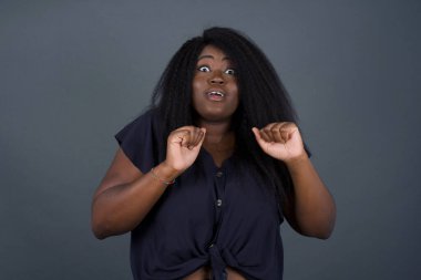 İnsan yüzü ifadeleri ve duyguları. Paniğe kapılmış genç Afro-Amerikan kadın portresi, ellerini yüzüne yakın tutuyor, ağzı sonuna kadar açık. Umutsuzluk ve şok içindeki bir kadın