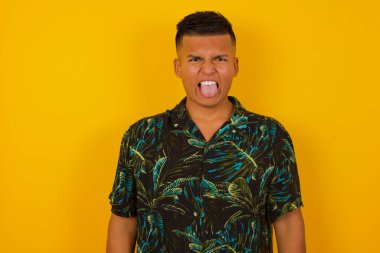 Vücut dili. Duvara karşı poz veren, suratını asan, bir şeyden tiksinen, stresli İspanyol bir adam..