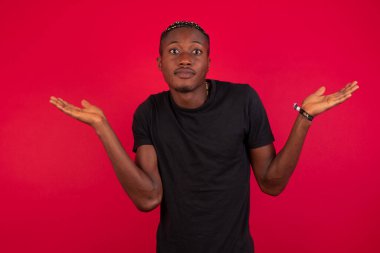 Kafası karışmış, kolları açık, omuzlarını silkip 