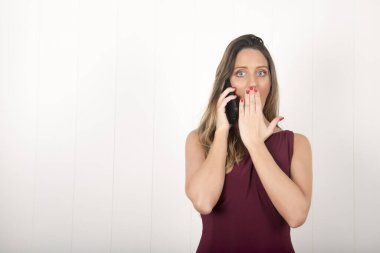 Stüdyoda akıllı telefonu olan genç ve güzel bir kadın.