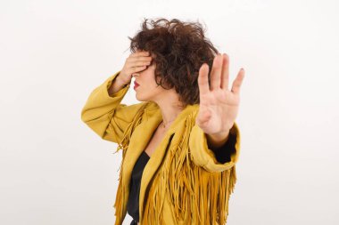 İnsanlar, vücut dili. Genç bir kadın gözlerini avuç içi ile kapar ve dur hareketi yapar, herkesten saklanmaya çalışır. Bana bakma, görmek istemiyorum, utanıyorum ya da korkuyorum..