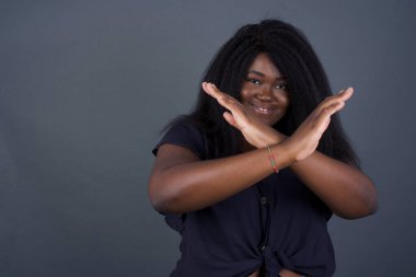 Tecrit edilmiş arka planda duran Afrikalı Amerikalı kadın. Reddedilme ifadesi olumsuz işaret göndererek el ele tutuşuyor mu?.