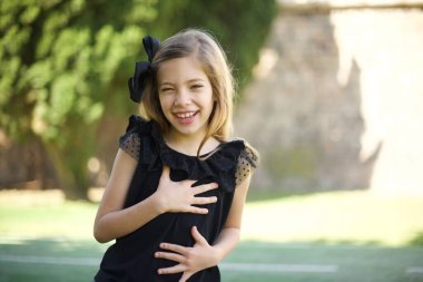 Neşeli Avrupalı öğrenci güzel şakalara güler, günlük kıyafetler giyer ve gözlük takar, parkta durur. 