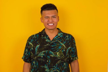 Sevimli, genç, İspanyol bir erkek mutlu bir ifadeyle gözlerini kırpıyor. Yüz ifadeleri ve insanların duygu konsepti.