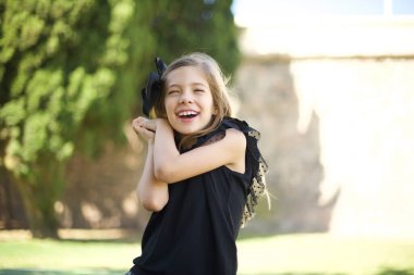 Tatlı yüzlü, hayalperest bir genç kız, gözlerini kapatıyor, ellerini yüzüne çarpıyor, hoş bir şeyler düşünüyor, parkta poz veriyor. 