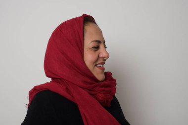 Sağlıklı cildi olan, gülümseyen olgun Müslüman bir kadının profili derin bir ifadeye sahiptir. Açık havada yürümeye hazırdır.
