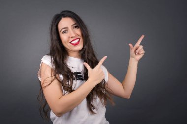 Gri arkaplanı işaret eden güzel kadın.  