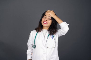 Tüh, ne yaptım ben? Tıp üniforması giyen güzel bir kadın korkmuş ve pişmanlık dolu bir ifadeyle alnına el ele tutuşuyor..