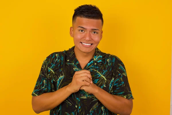 Gri stüdyo arka planında izole edilmiş yakışıklı İspanyol erkek portresi. Genç, duygusal, şaşkın, ağzı açık, İspanyol bir adam. İnsani duygular, yüz ifadesi kavramı. 