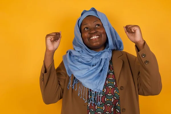 Emocionado Joven Afroamericana Musulmana Mujer Ganadora Levantando Los Puños Con —  Fotos de Stock