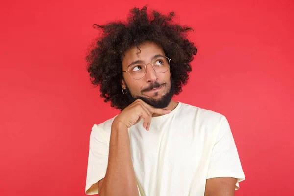 Joven Con Pelo Afro Pensando Contra Pared Roja — Foto de Stock