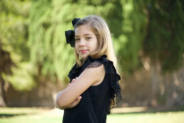 Kollarını Kavuşturmuş Neşeli Beyaz Bir Kızın Resmi Kameraya Bakıp Gülümsüyor — Stok fotoğraf