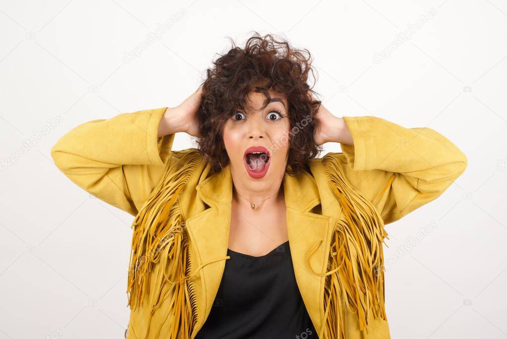 Excited  overjoyed woman screams after recieving good news, keeps hands on head, can't believe it.