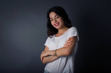 İçerde kollarını kavuşturmuş neşeli beyaz bir kadının görüntüsü. Kameraya bakıp gülümsüyor. Kendine güvenen kız..