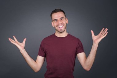 Neşeli adam hoş bir jest yapıyor. Arka planda izole bir şekilde kollarını havaya kaldırıyor..