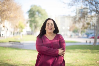 Parktaki mutlu orta yaşlı güzel Arap kadın.  