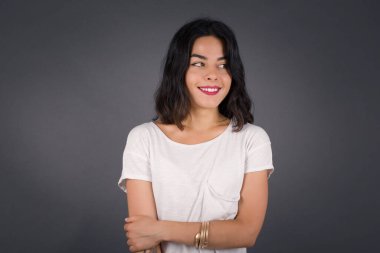 Hayalperest, genç bir kadın, düşünceli bir yüz ifadesi var, elleri havada, dudaklarını ısırıyor, gri duvara karşı hoş bir poz düşünüyor..