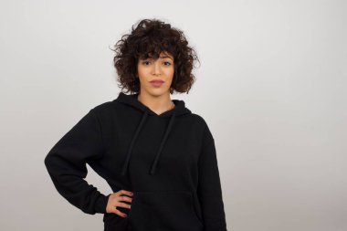 Stüdyo çekiminde kadın elini kalçasından ayırmıyor. Gri arka plan üzerinde izole edilmiş..