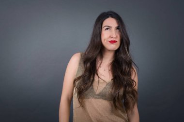 Gri arka planda düşünen güzel bir kadın.  