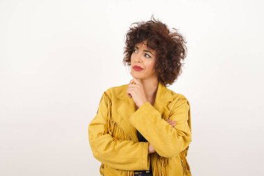 Çene altında eli olan, şüpheli ve şüpheci bir ifadeyle yan bakan zarif Avrupalı genç bir kadının izole edilmiş portresi. Arka planda kapalı duruyor..