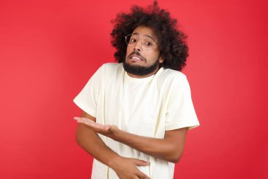 Kızıl duvarda afro saçlı genç adam kafası karışmış.   