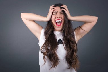 Güzel bir kadın bağırıyor Gri arka planda duruyor. 